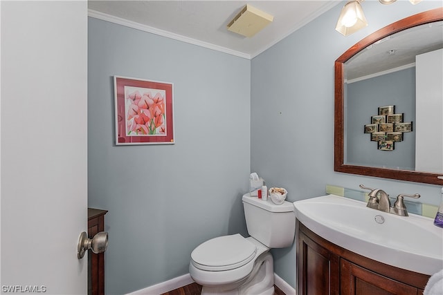 bathroom with toilet, ornamental molding, and vanity