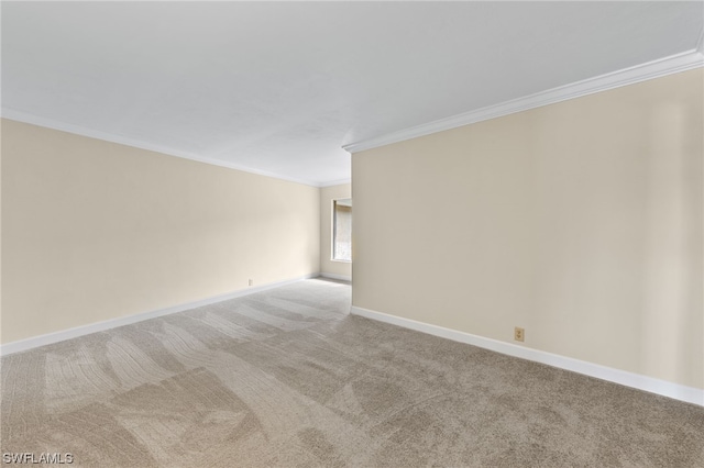 unfurnished room featuring baseboards, crown molding, and light colored carpet