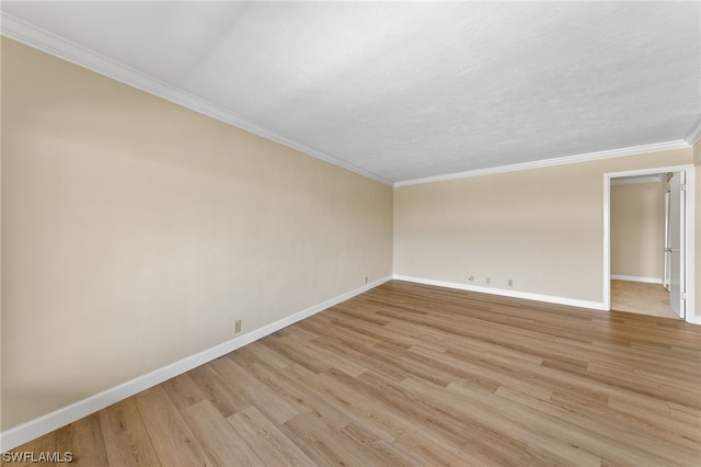 unfurnished room with light wood-style flooring, baseboards, and ornamental molding