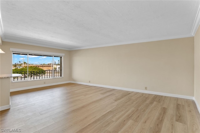 empty room featuring baseboards, crown molding, a textured ceiling, and light wood-type flooring