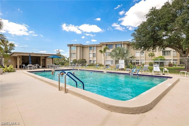 community pool with fence and a patio area