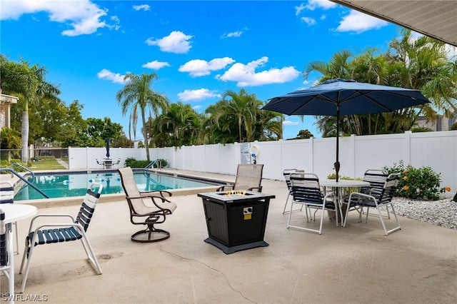 community pool with a fenced backyard, a patio, and outdoor dining area