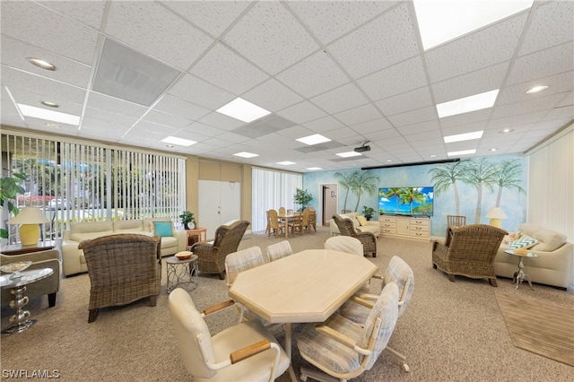 dining space featuring a drop ceiling and light colored carpet