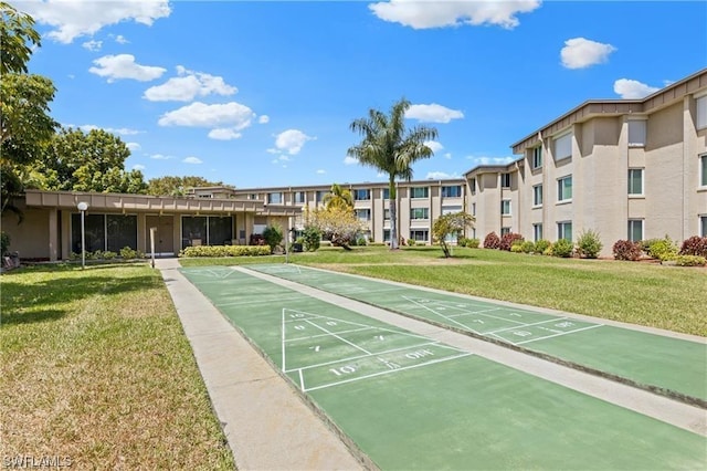 surrounding community with a yard and shuffleboard