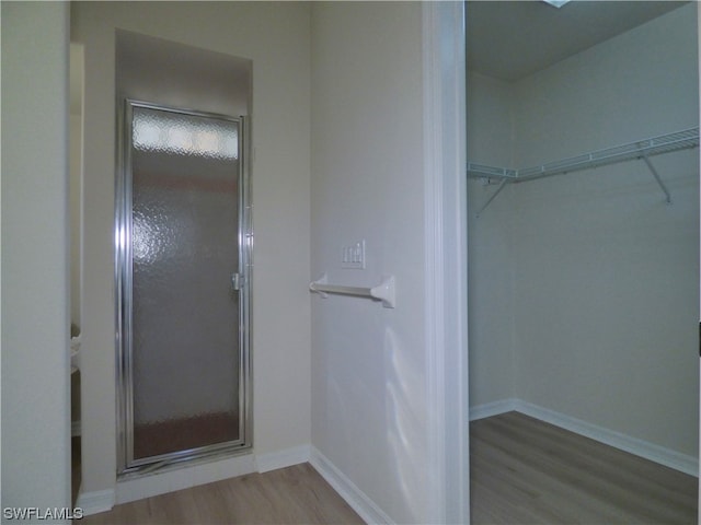 bathroom featuring a shower with door and wood-type flooring