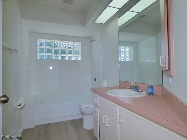 full bathroom with tub / shower combination, hardwood / wood-style flooring, vanity, and toilet