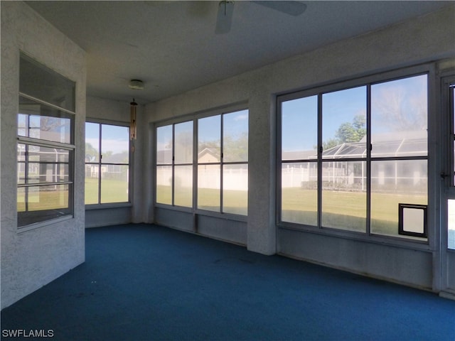 unfurnished sunroom featuring ceiling fan