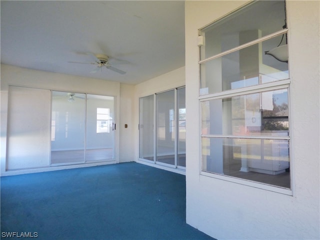 unfurnished sunroom with ceiling fan