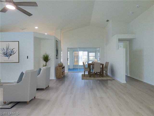 living room with lofted ceiling, ceiling fan, and light hardwood / wood-style floors