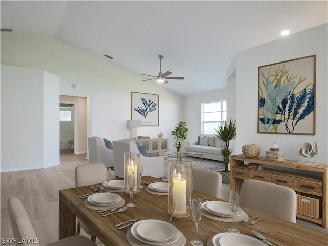 dining room featuring ceiling fan, light wood-type flooring, and vaulted ceiling