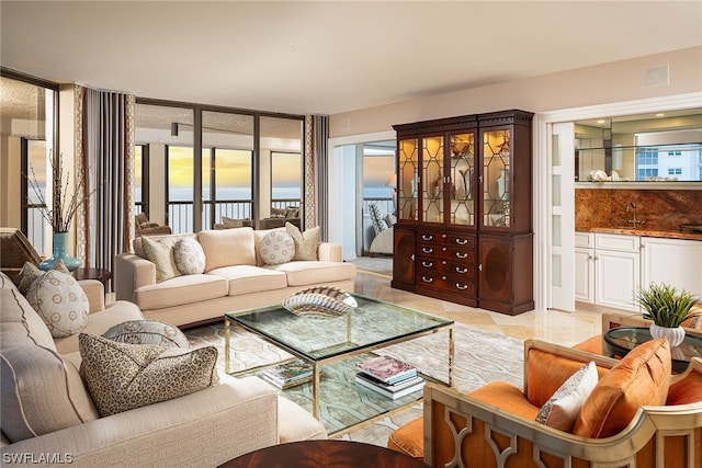 living room with plenty of natural light, light tile floors, and sink