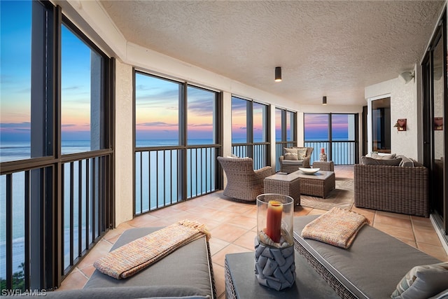 sunroom featuring plenty of natural light and a water view