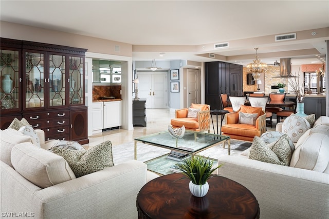 living room featuring a chandelier, a wealth of natural light, and light tile flooring