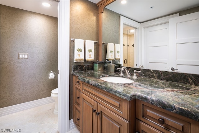 bathroom featuring toilet, vanity with extensive cabinet space, and tile floors