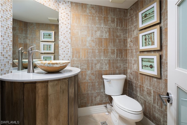 bathroom featuring tile walls, tile floors, toilet, and vanity