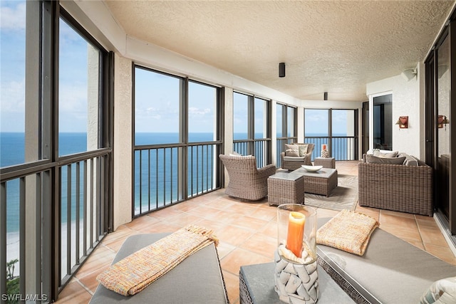 sunroom featuring a water view