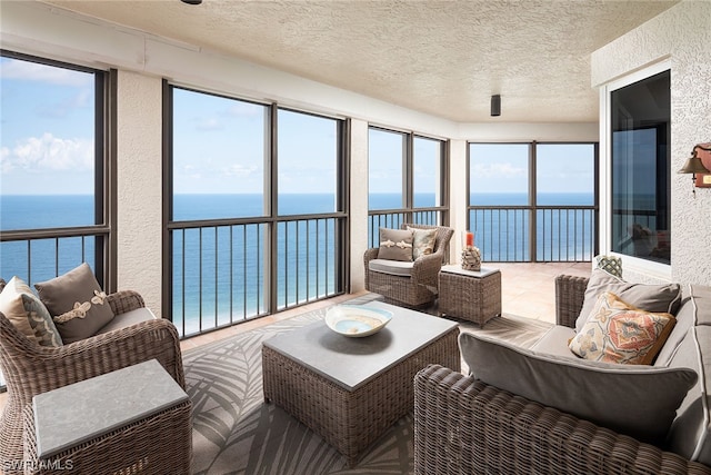 sunroom / solarium featuring a water view