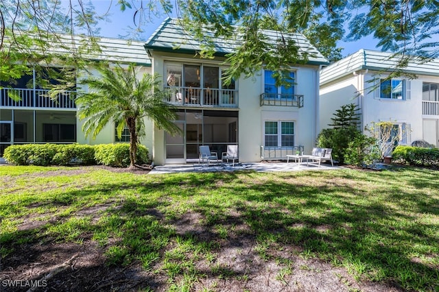 back of property with a patio and a lawn