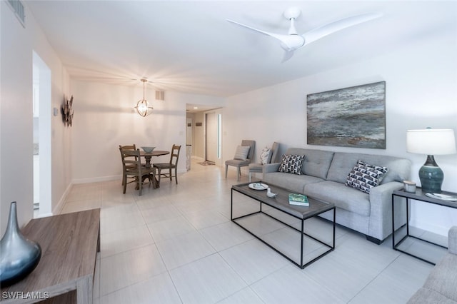 living area featuring light tile patterned floors, baseboards, visible vents, and ceiling fan