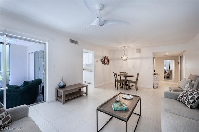 living area with a ceiling fan, visible vents, and light tile patterned floors