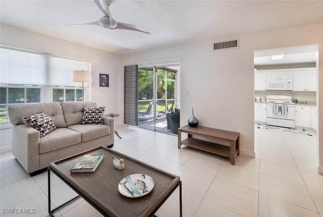 living room featuring a ceiling fan, visible vents, and light tile patterned floors