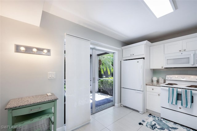 kitchen with white appliances, white cabinets, decorative backsplash, and light tile patterned floors