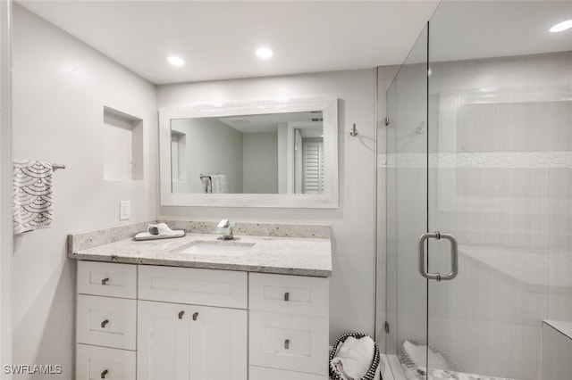 bathroom featuring a stall shower, vanity, and recessed lighting