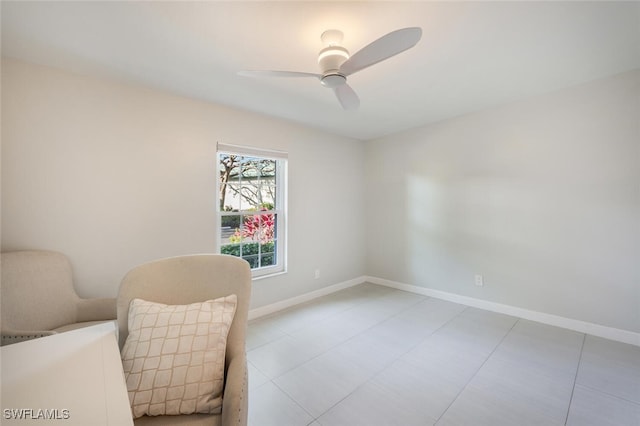 sitting room featuring ceiling fan and baseboards