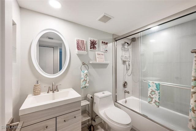 full bath with visible vents, shower / bath combination with glass door, vanity, and toilet