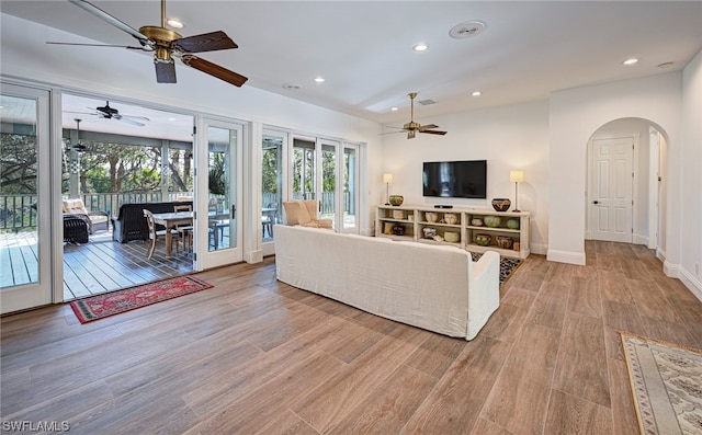 living room with light hardwood / wood-style floors and ceiling fan