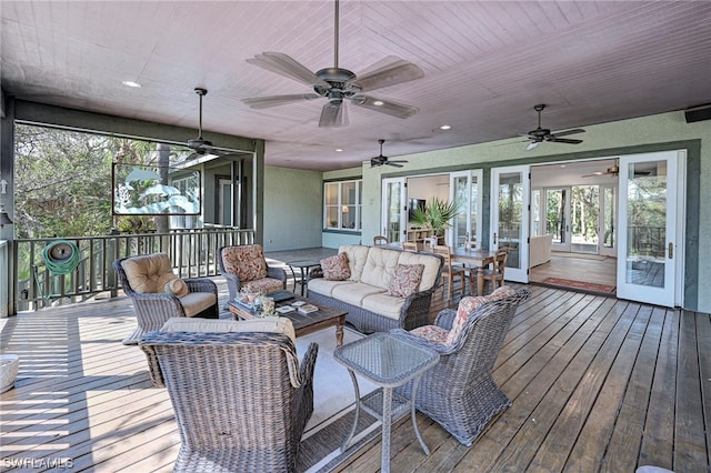 sunroom featuring ceiling fan and french doors