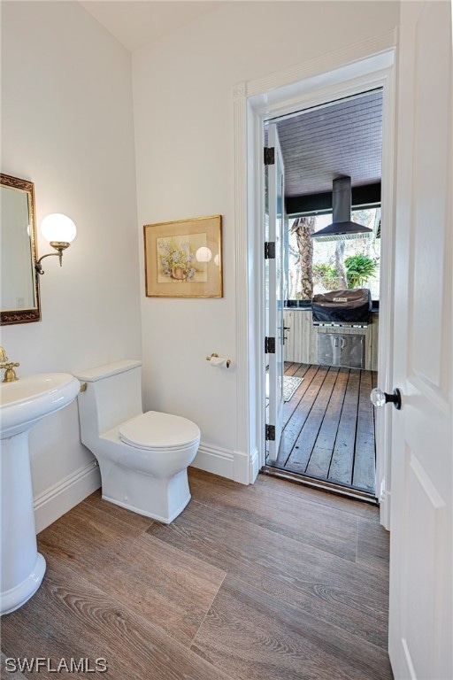 bathroom with toilet and hardwood / wood-style flooring