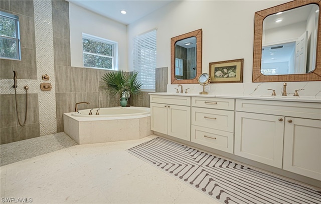 bathroom featuring shower with separate bathtub, tile floors, oversized vanity, and dual sinks