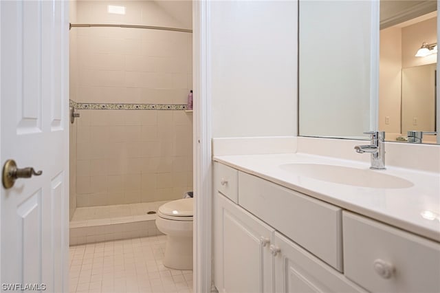 bathroom with toilet, tiled shower, vanity with extensive cabinet space, and tile flooring