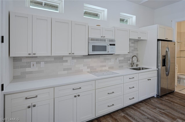 kitchen with white appliances, white cabinetry, sink, backsplash, and dark hardwood / wood-style flooring