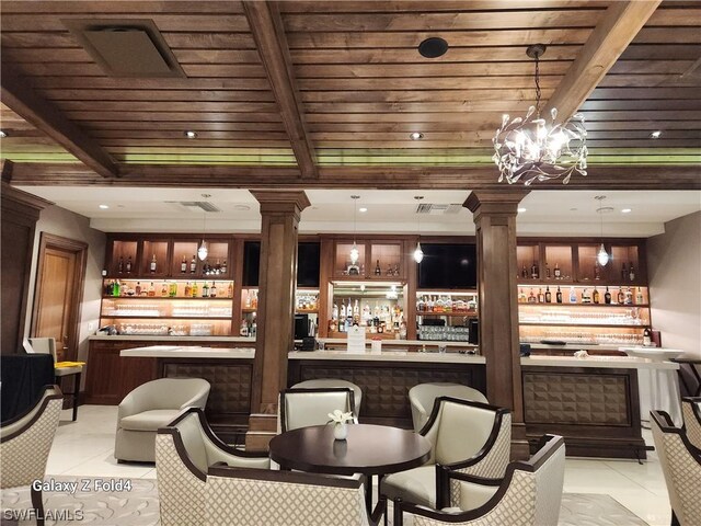 bar with hanging light fixtures, light tile patterned floors, and beam ceiling