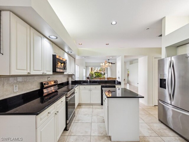 kitchen with sink, white cabinetry, appliances with stainless steel finishes, and kitchen peninsula