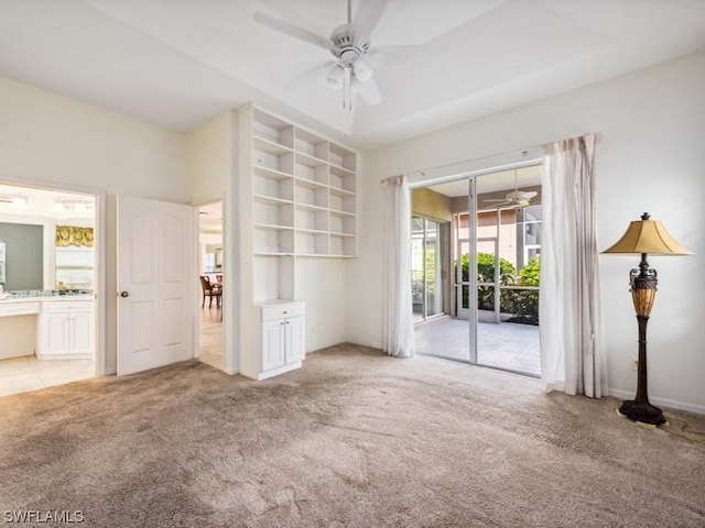 unfurnished living room with ceiling fan, light colored carpet, and built in features