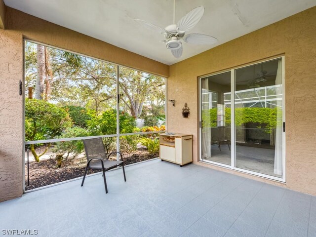 unfurnished sunroom with ceiling fan and plenty of natural light