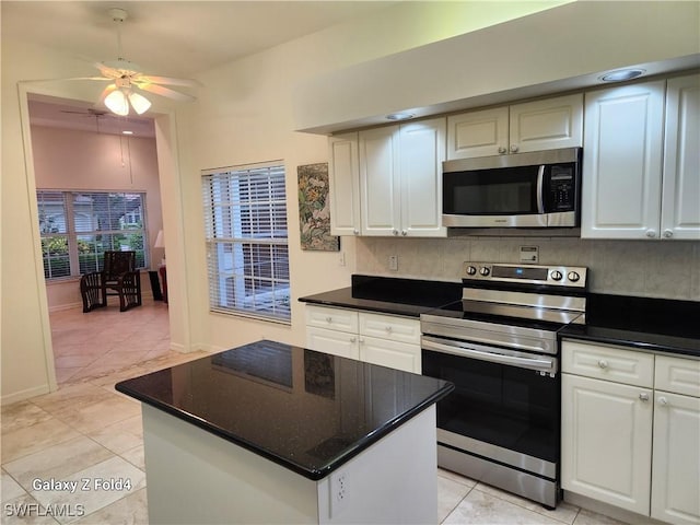 kitchen featuring ceiling fan, stainless steel appliances, white cabinetry, and tasteful backsplash