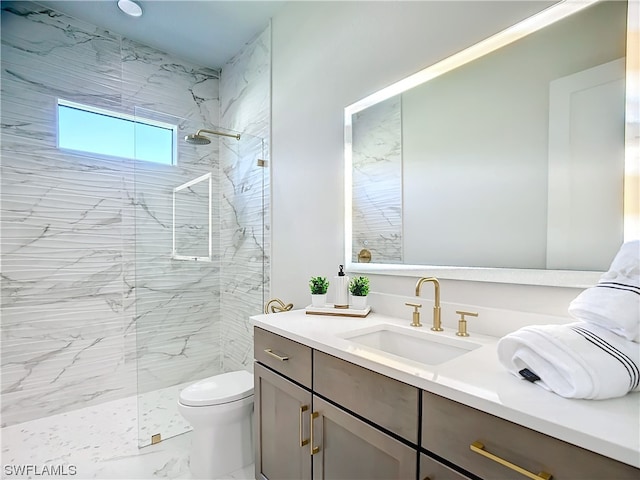 bathroom featuring vanity, tiled shower, and toilet