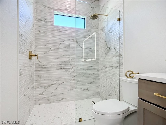 bathroom featuring vanity, tiled shower, and toilet