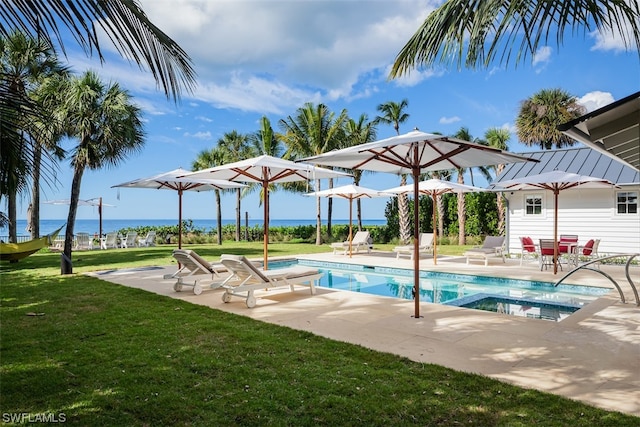 view of pool with a water view, a lawn, and a patio area