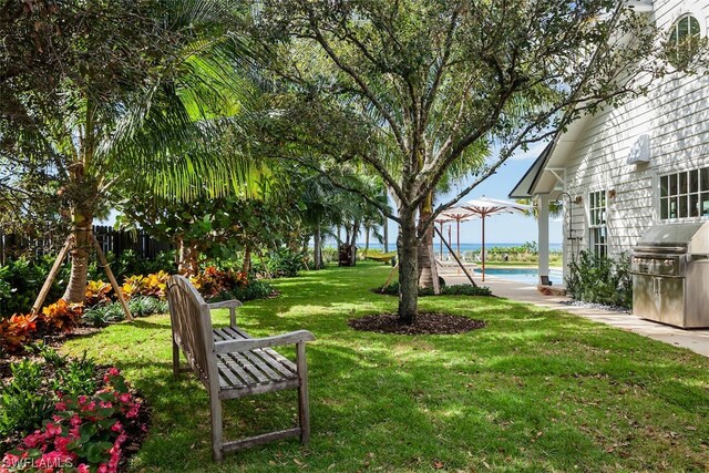 view of yard with exterior kitchen and a water view