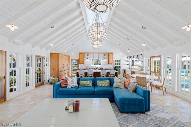 living room featuring a chandelier, light tile floors, high vaulted ceiling, and beamed ceiling