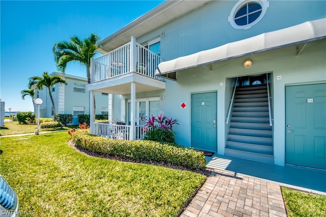 exterior space with a balcony and a front yard