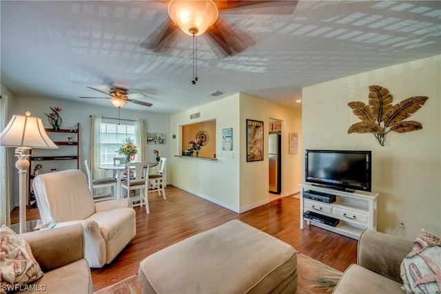 living room with ceiling fan and hardwood / wood-style flooring