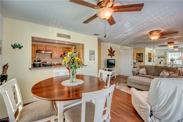 dining area with ceiling fan and hardwood / wood-style flooring