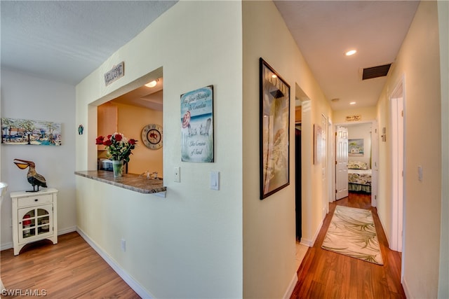 corridor with light hardwood / wood-style floors