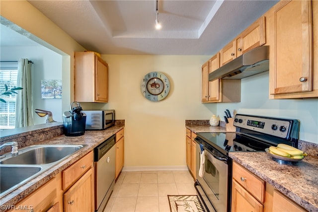 kitchen with light brown cabinets, stainless steel appliances, light tile flooring, a raised ceiling, and sink